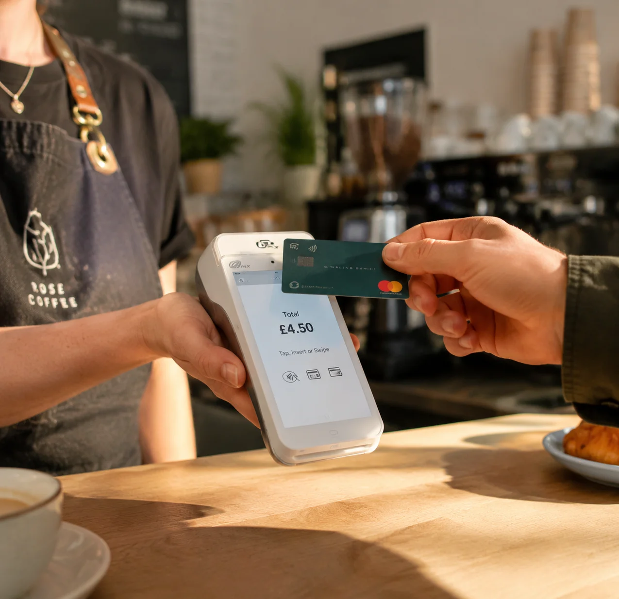 Barista taking a contactless payment on a Monek card machine